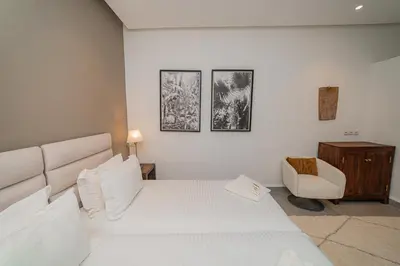 a bedroom with a white bed and a chair at Riad Sabrawa in Marrakech