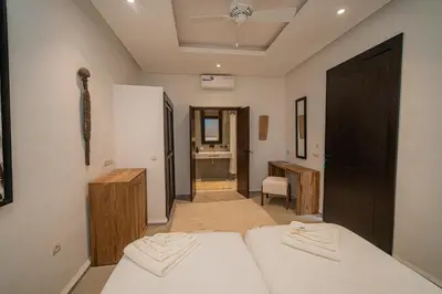 a bedroom with two beds and a desk in it at Riad Sabrawa in Marrakech
