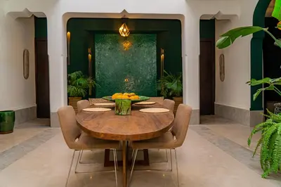 a dining room with a wooden table and chairs at Riad Sabrawa in Marrakech