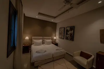 a bedroom with a bed and a chair at Riad Sabrawa in Marrakech