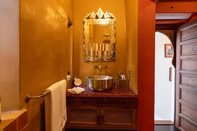 a bathroom with a sink and a mirror at Riad exclusif 3 chambres piscine service hôtel Kasbah Amour in Marrakech
