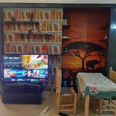 a living room with a table and a tv and book shelves at دوبلكس في مراكش in Marrakech