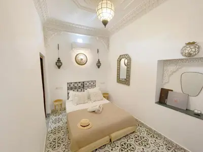 a bedroom with a bed with a hat on it at Douria FARAH, Authentique in Marrakech