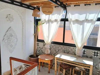 a room with a table and a window with curtains at Douria FARAH, Authentique in Marrakech