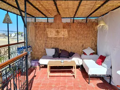 a patio with two beds and a table on a balcony at Douria FARAH, Authentique in Marrakech