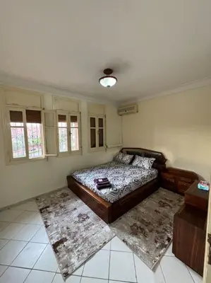 a bedroom with a bed and two rugs in it at appartement Holiday relais près musée Saint-Laurent in Marrakech