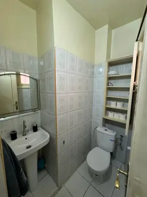 a white bathroom with a toilet and a sink at appartement Holiday relais près musée Saint-Laurent in Marrakech