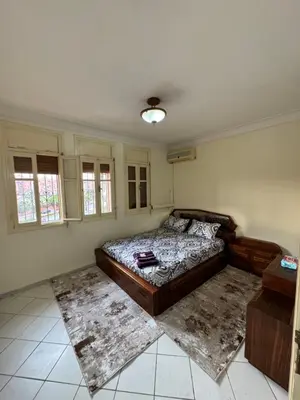 a bedroom with a bed and two rugs in it at appartement Holiday relais près musée Saint-Laurent in Marrakech