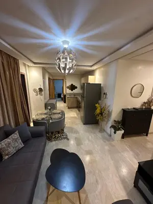 a living room with a blue couch and a chandelier at Yany cosy appartement in Marrakech