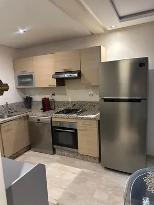 a kitchen with a stainless steel refrigerator and cabinets at Yany cosy appartement in Marrakech