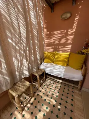 a room with a bed and a window with yellow pillows at Yany cosy appartement in Marrakech
