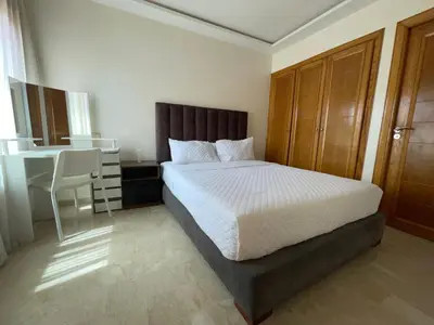 a bedroom with a bed and a desk and a table at Yany cosy appartement in Marrakech