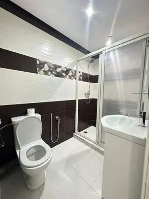 a bathroom with a toilet and a shower and a sink at Grand Appartement Piscine Guéliz in Marrakech