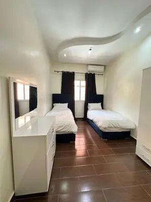 a room with two beds and a desk in it at Grand Appartement Piscine Guéliz in Marrakech