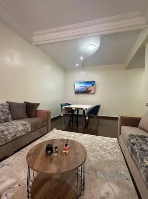 a living room with a couch and a table at Grand Appartement Piscine Guéliz in Marrakech