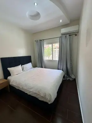 a bedroom with a white bed with a window at Grand Appartement Piscine Guéliz in Marrakech