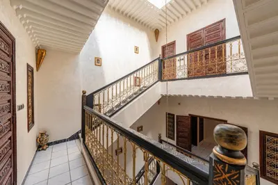 a staircase in a house with wooden doors at Riad Malika in Marrakech