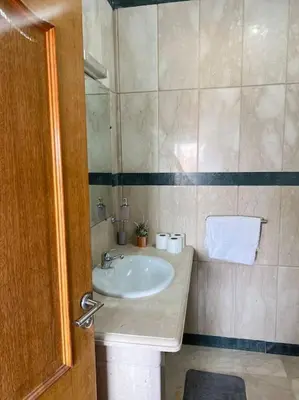 a bathroom with a sink and a mirror and a door at New nice apartment city center swimming pool wifi in Marrakech