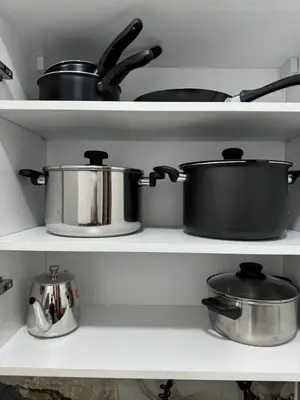 three pots and pans on shelves in a kitchen at Luxueux appartement -70 haut gamme Guéliz in Marrakech