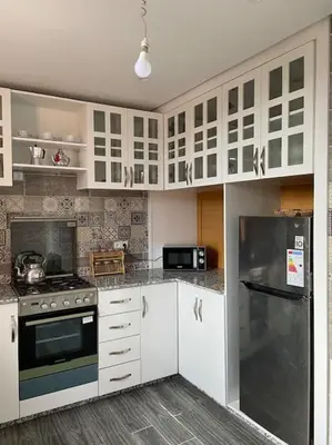 a kitchen with white cabinets and a stainless steel refrigerator at Marrakech Dar El Hijazi 2 in Marrakech