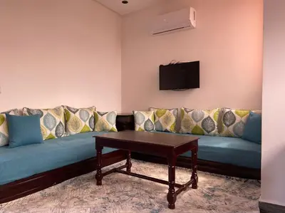 a living room with a blue couch with a table at Marrakech Dar El Hijazi 2 in Marrakech