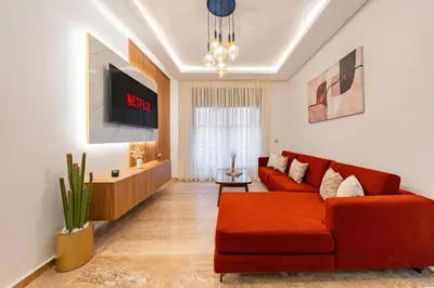 a living room with a red couch and a tv at Apprtement -74-de luxe haut gamme guéliz in Marrakech