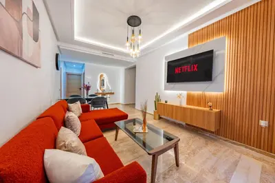 a living room with a red couch and a tv at Apprtement -74-de luxe haut gamme guéliz in Marrakech
