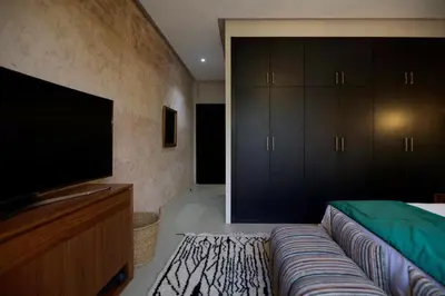 a bedroom with a couch and a flat screen tv at Villa zen in Marrakech