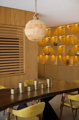 a dining room with a wooden table and yellow chairs at Villa zen in Marrakech