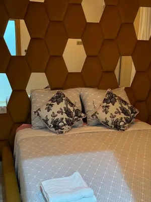 a bed with a brown headboard and pillows at Luxueuse Apparemment -143 haut standing in Marrakech