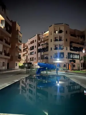 a swimming pool with a blue slide in front of a building at Premuim village Marrakech in Marrakech