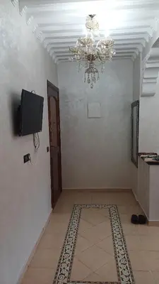 a room with a chandelier and a door with a rug at الأزهار in Marrakech