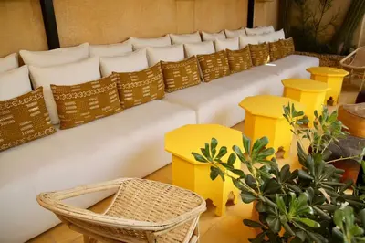 a long white couch with yellow tables and chairs at Riad MONDRIAH in exclusivity only for you in Marrakech