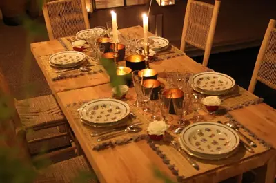 a wooden table with plates and candles on it at Riad MONDRIAH in exclusivity only for you in Marrakech