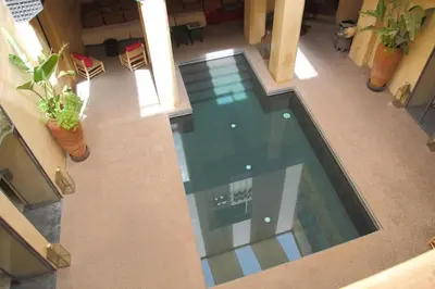an indoor swimming pool in a building with plants at Riad MONDRIAH in exclusivity only for you in Marrakech