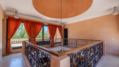 a room with a balcony with red curtains at la villa du golf in Sfiani