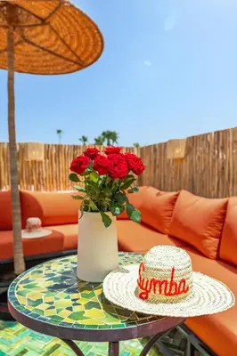 a table with a vase with red roses on it at Riad Symba Exclusive with New Heated Pool and Breakfast Included in Marrakech