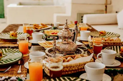 a table topped with plates and glasses of orange juice at Dar Inara in Marrakech