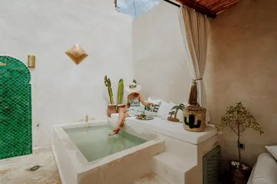 a woman sitting in a bath tub in a room at Dar Inara in Marrakech