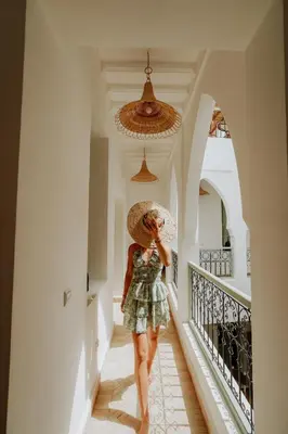a woman walking down a hallway with a hat at Dar Inara in Marrakech