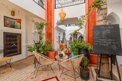 a room with chairs and plants and a chalkboard at Riad 5 sens in Marrakech