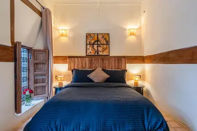 a bedroom with a blue bed and a window at Riad 5 sens in Marrakech