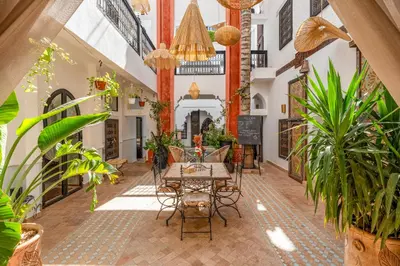 a courtyard with plants and a table in a building at Riad 5 sens in Marrakech