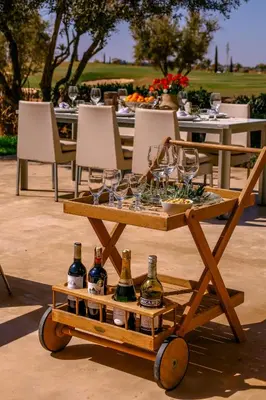 a wooden cart with wine glasses on it at Villa Angel 42 Al Maaden Golf Resort in Marrakech