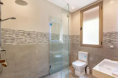 a bathroom with a toilet and a glass shower at Villa Narjisse , Élégance et Calme, piscine privée in Marrakech