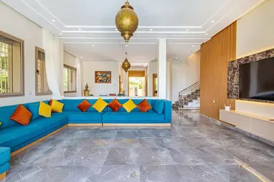 a living room with a blue couch with colorful pillows at Villa Narjisse , Élégance et Calme, piscine privée in Marrakech