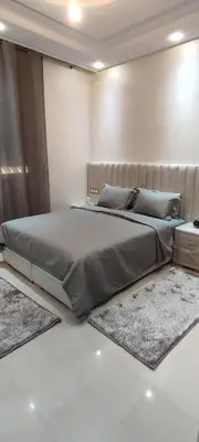a large bed in a bedroom with two rugs at مراكش تاركة in Marrakech