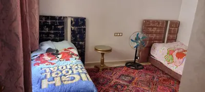 a small bedroom with a bed and a fan at مراكش تاركة in Marrakech