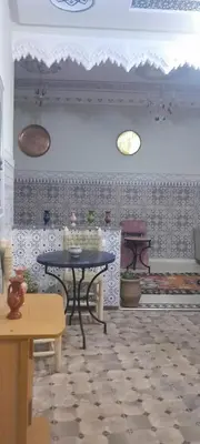 a room with a table and a wall with tiles at Riad Ramadan House Marrakech in Marrakech