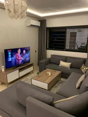a living room with a couch and a flat screen tv at Nour5 in Marrakech